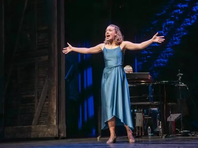 Rosie Sutton singing with arms outstretched